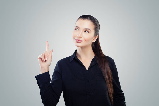 Happy business woman pointing up on gray background. Friendly woman portrait - Фото, зображення