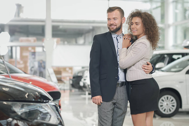 Couple choosing automobile in car center. - Foto, afbeelding