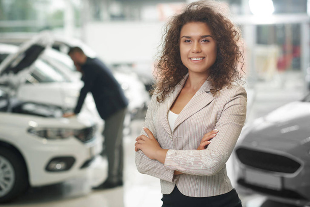 Female manager posing in car showroom. - Foto, Imagen