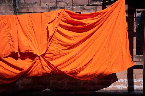 texture of orange robe of a Buddhist monk or novice for background - Photo, Image