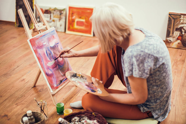 Літня жінка малює у себе вдома. пенсійне хобі
.  - Фото, зображення