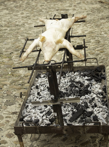 Cerdo asado en brasas, celebración y comida tradicional
 - Foto, Imagen