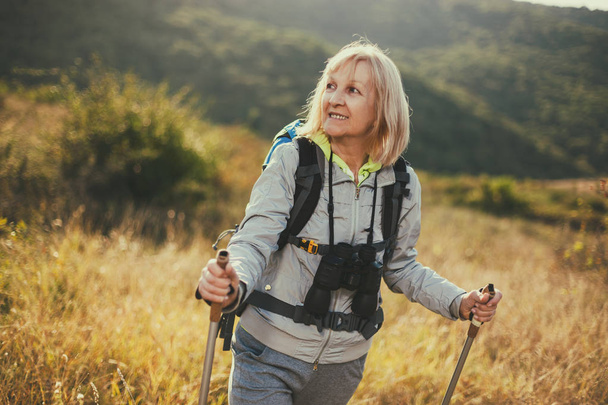 年配の女性は、山のハイキングです。アクティブな退職金.  - 写真・画像