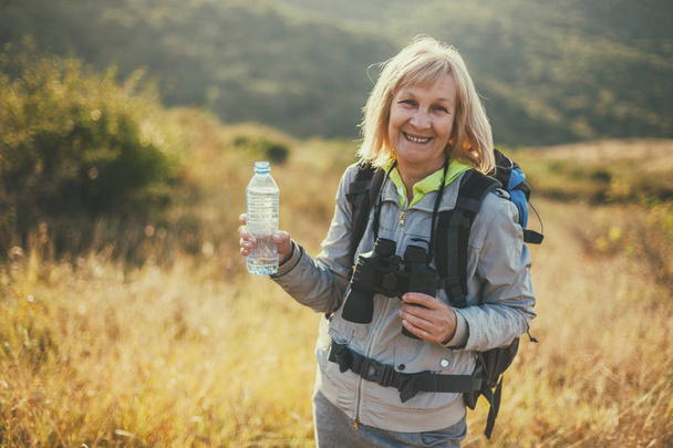 Senior woman is hiking in mountain. Active retirement.  - Фото, изображение