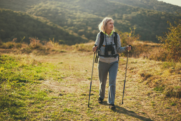 Una mujer mayor está de excursión en la montaña. Jubilación activa
.  - Foto, Imagen