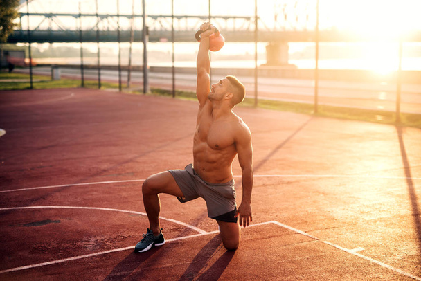Handsome man working exercises in early morning with sunrise. Fitness training outdoors. - Fotoğraf, Görsel