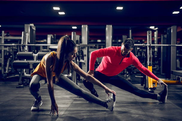 Сильна посадка красивої пари розтягує м'язи після важкого тренування в спортзалі
. - Фото, зображення