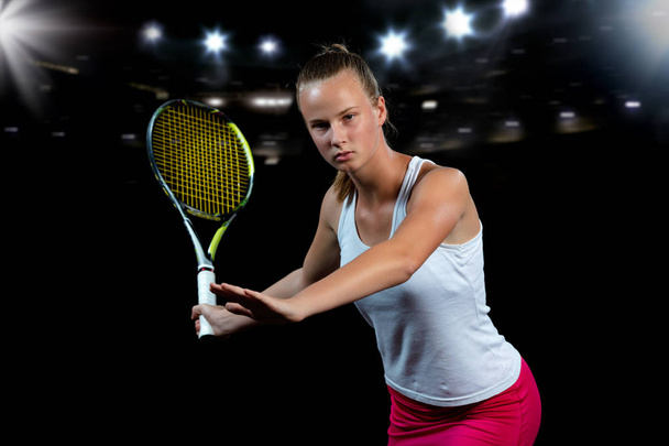 Beautiful girl tennis player with a racket on dark background with lights - Zdjęcie, obraz