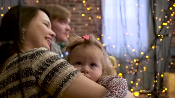 Boldog család anya és a baba játszani a karácsonyi ünnepek, télen a kislányom ragyog a háttérben. Boldog család anya és gyermeke lánya a karácsony - Felvétel, videó