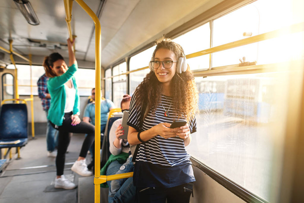 Mladá krásná žena poslechu hudby ve sluchátkách v autobuse - Fotografie, Obrázek