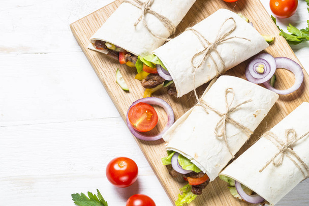Burritos tortilla enveloppe de boeuf et légumes sur fond blanc
 - Photo, image