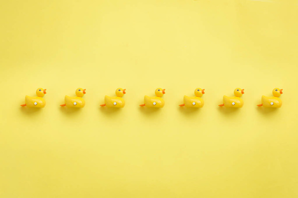 eine Reihe gelber Enten auf gelbem Hintergrund. - Foto, Bild