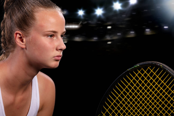 Beautiful girl tennis player with a racket on dark background with lights - Фото, изображение