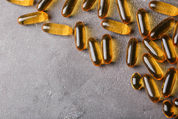 Capsule pills on grey textured background - Foto, Imagen