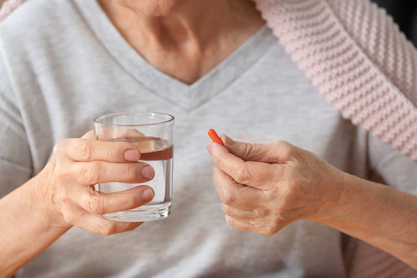 Elderly woman taking pill, closeup - Photo, Image