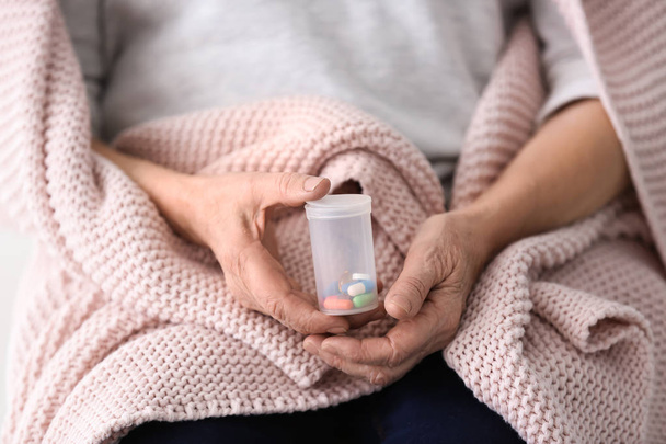 ältere Frau hält Behälter mit verschiedenen Pillen, Nahaufnahme - Foto, Bild