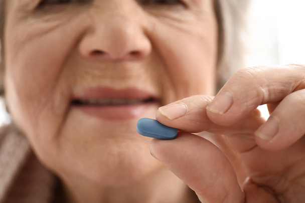 Пожилая женщина принимает таблетки, крупным планом
 - Фото, изображение
