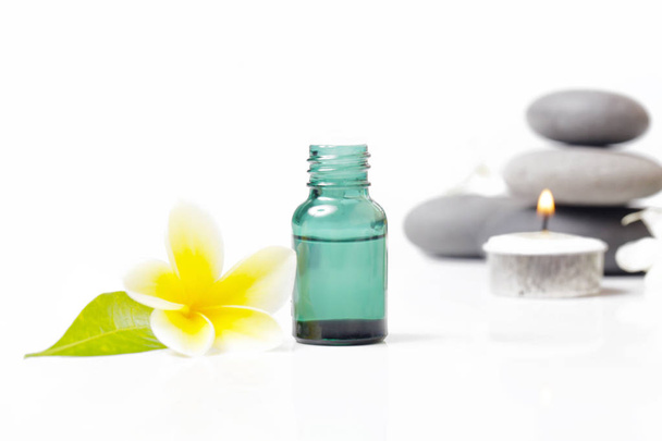 Botellas cosméticas verdes con piedras zen y flor de frangipani
 - Foto, Imagen