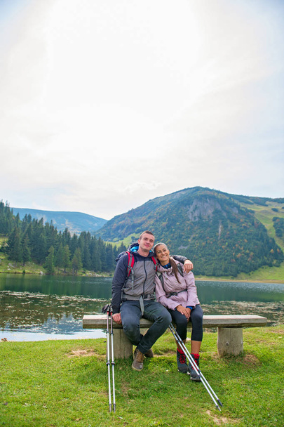 young couple of backpackers near the lake in mountains - Foto, Imagem