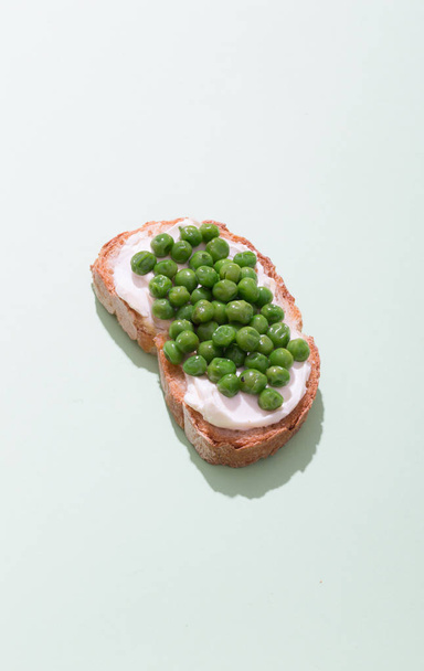 Green pea sandwich prepared with creamy cheese and bread on the green background - Φωτογραφία, εικόνα