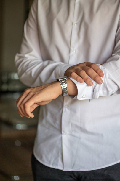 spanischer Mann forscht und arbeitet im Haus, macht ein Start-up, macht Notizen und schaut auf seine Armbanduhr - Foto, Bild