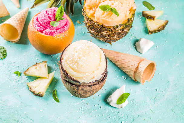 Conceito de férias de verão, definir vários sorvetes de sorvete tropical, sucos congelados em abacaxi, toranja e coco, luz azul espaço de cópia de fundo de concreto
 - Foto, Imagem