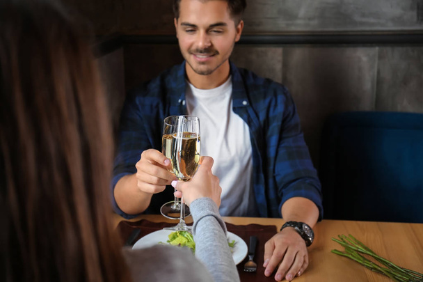 Loving couple with glasses of champagne in restaurant on romantic date - Photo, Image
