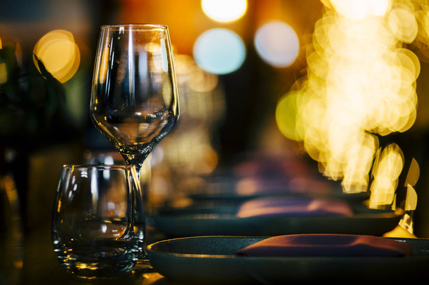 Luxury table settings for fine dining with and glassware, beautiful blurred  background. For events, weddings.  Preparation for holiday  Christmas and Hanukkah dinner night. props for weddings, birthdays, and celebrations. - Foto, Imagen