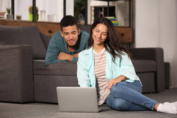Casal jovem com laptop em casa
 - Foto, Imagem