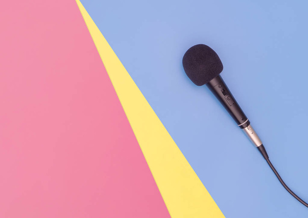 Black microphone on blue pink yellow background for music concept - Foto, Bild