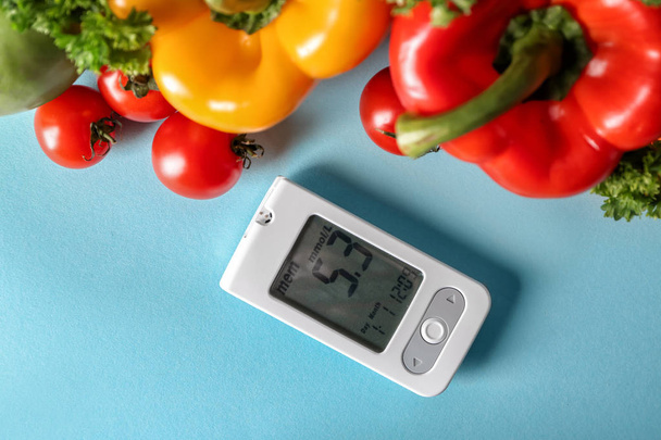 Цифровой глюкометр со здоровой пищей на цветном фоне. Сахарный диабет
 - Фото, изображение