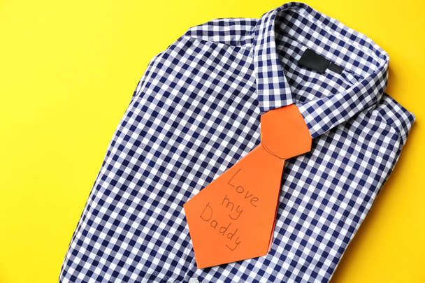 Camisa masculina con tarjeta de felicitación creativa para el Día del Padre sobre fondo de color
 - Foto, Imagen
