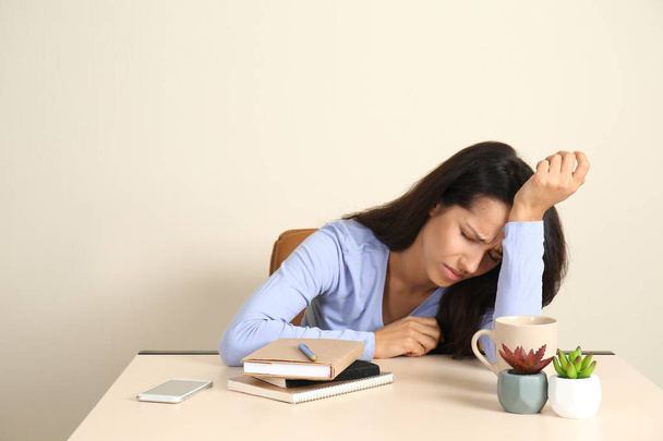 Mujer joven estresada sentada a la mesa en la oficina
 - Foto, imagen