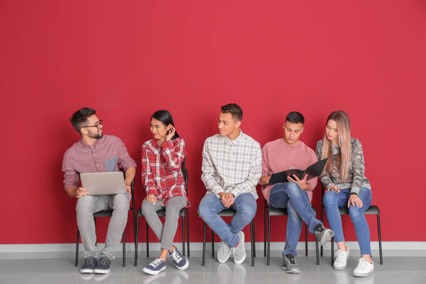 Fiatal diákok ül közel színes fal - Fotó, kép