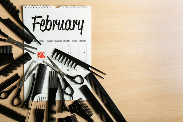 Calendar with hairdresser's tools on wooden background - Photo, Image