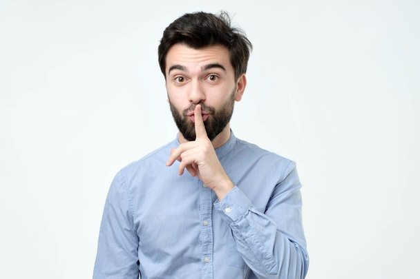 Ισπανόφωνος άνθρωπος τοποθετώντας το δάχτυλο στα χείλη ως εάν να πω, shhhhh, είναι ήσυχο, σιωπή. - Φωτογραφία, εικόνα