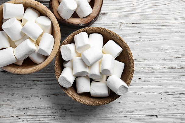 Ciotole con gustoso marshmallow su sfondo di legno
 - Foto, immagini
