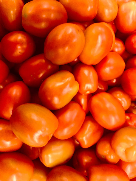 plusieurs petites tomates créant un fond rouge et texturé
 - Photo, image