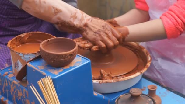 Handen van pottenbakker leert het kind potten te maken. Concept - overdracht van ervaring, opleiding - Video