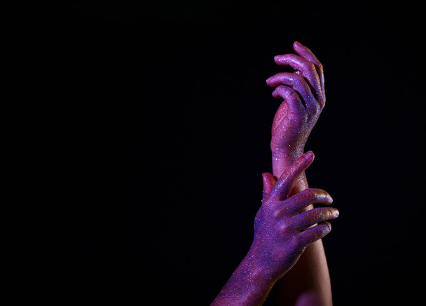 Painted female hands on dark background - Фото, изображение