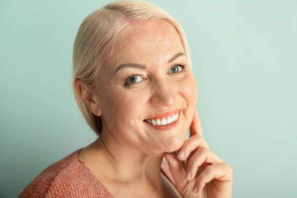 Portrait of beautiful mature woman on color background - Фото, зображення