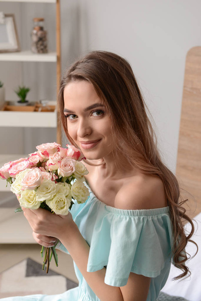 Portret van mooie jonge vrouw met boeket bloemen - Foto, afbeelding