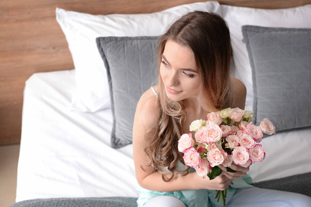 Beautiful young woman with bouquet of flowers at home - Foto, Imagem