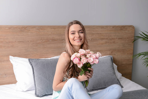 Schöne junge Frau mit Blumenstrauß zu Hause - Foto, Bild