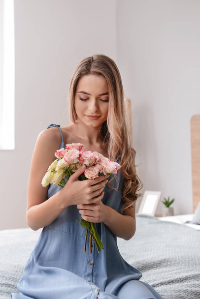 Beautiful young woman with bouquet of flowers at home - Foto, imagen