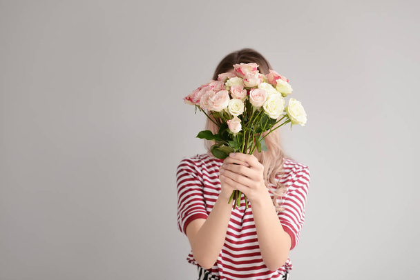 Krásná mladá žena s kyticí na šedém pozadí - Fotografie, Obrázek