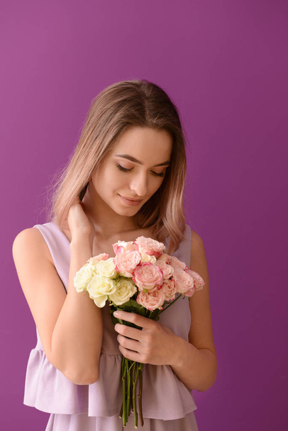 Beautiful young woman with bouquet of flowers on color background - Fotó, kép