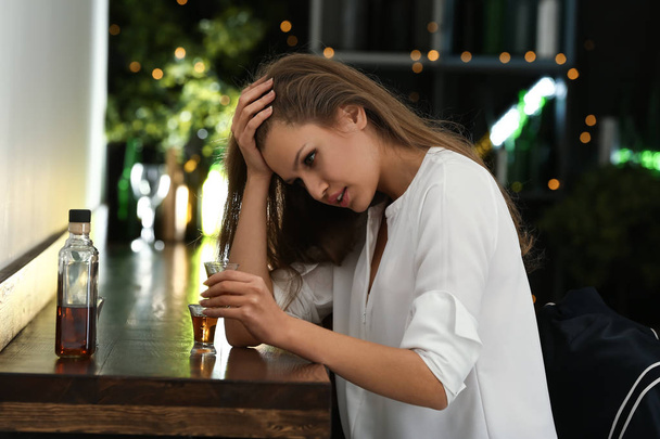 Mulher deprimida bebendo álcool no pub
 - Foto, Imagem