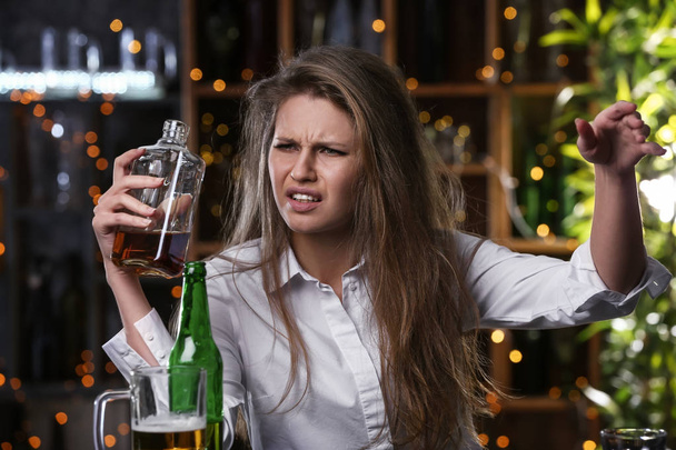Depressed woman drinking alcohol in bar - Photo, Image