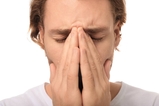 Mladý muž trpí bolest hlavy na bílém pozadí, closeup - Fotografie, Obrázek